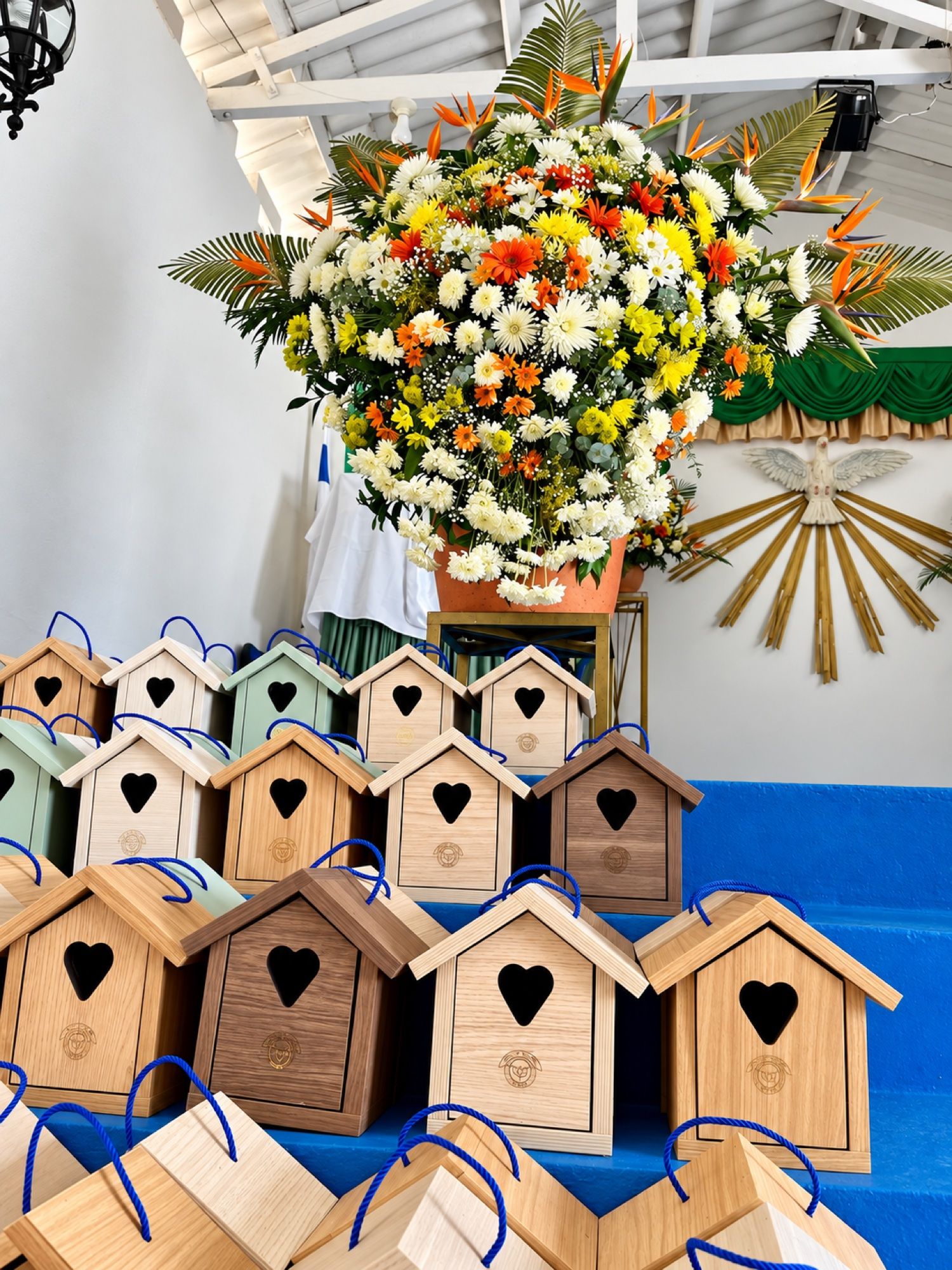 Casitas de madera con un corazón, junto a un arreglo de flores