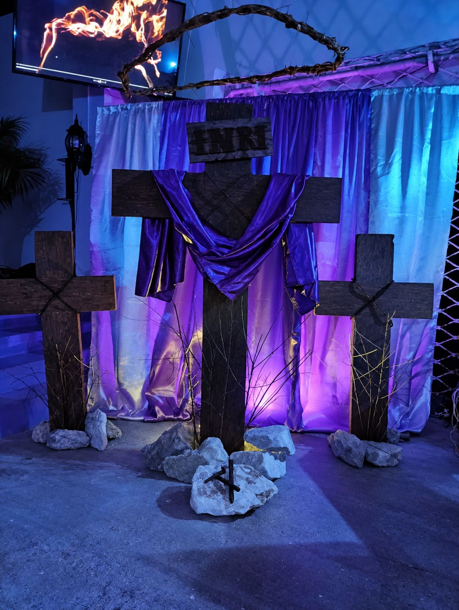 Altar con tres cruces de madera y un manto morado